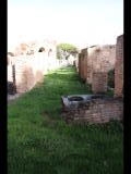 02308 ostia - regio v - insula xi - portico del monumento repubblicano (v,xi,4) - porticus - im vordergrund - edificio (v,xi,3) - bli ri osten - 01-2024.jpg